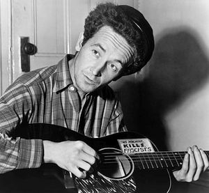 Woody Guthrie nel 1943 con la celebre chitarra contro il fascismo